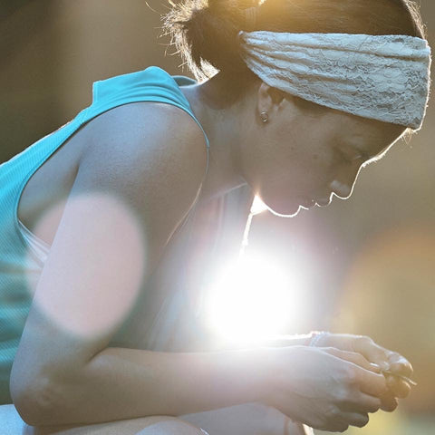 woman looking at a leaf light shining behind her