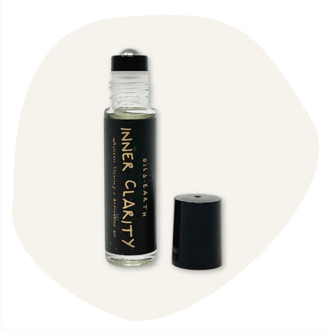 Oils.Earth Inner Clarity essential oil 10ml open roller bottle with cap on the side. tan background